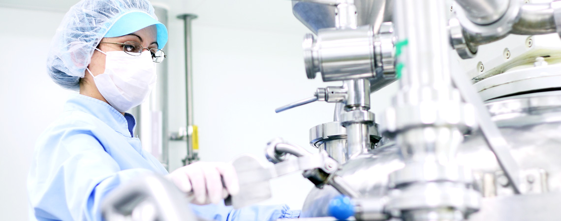 Pharmaceutical scientist working with manufacturing equipment